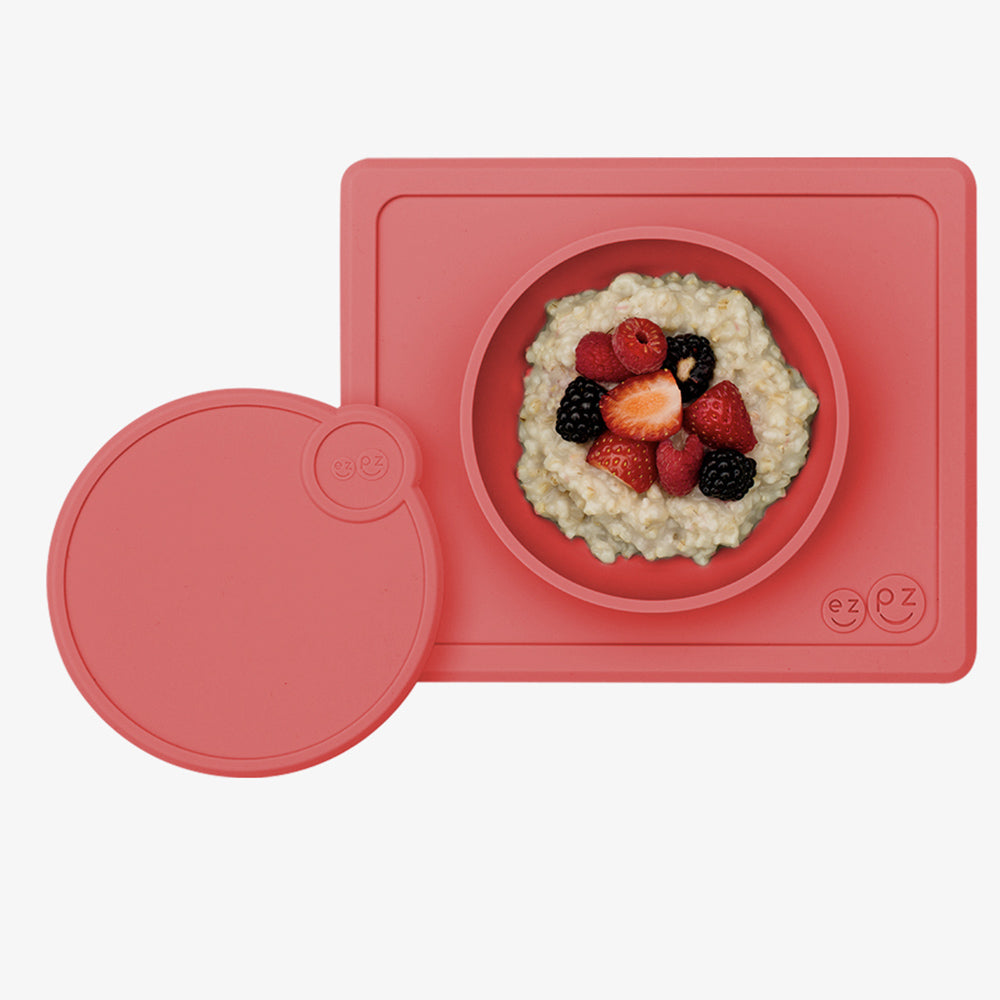 ezpz lid and mini bowl in coral with oatmeal and fruit in the bowl