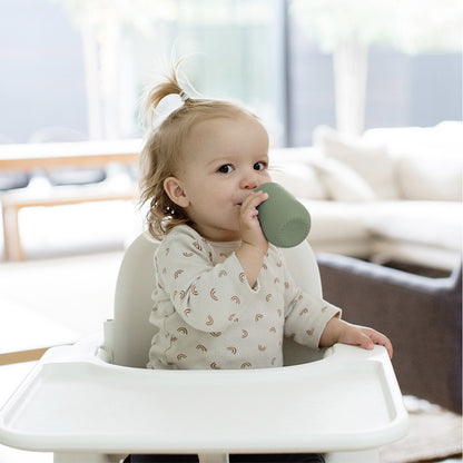 toddler drinking from the ezpz cup and straw training system in olive