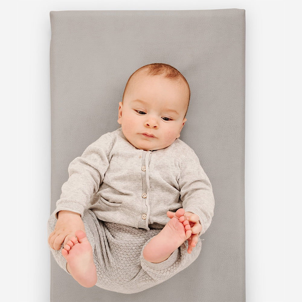baby laying on padded gathre micro mat in pewter